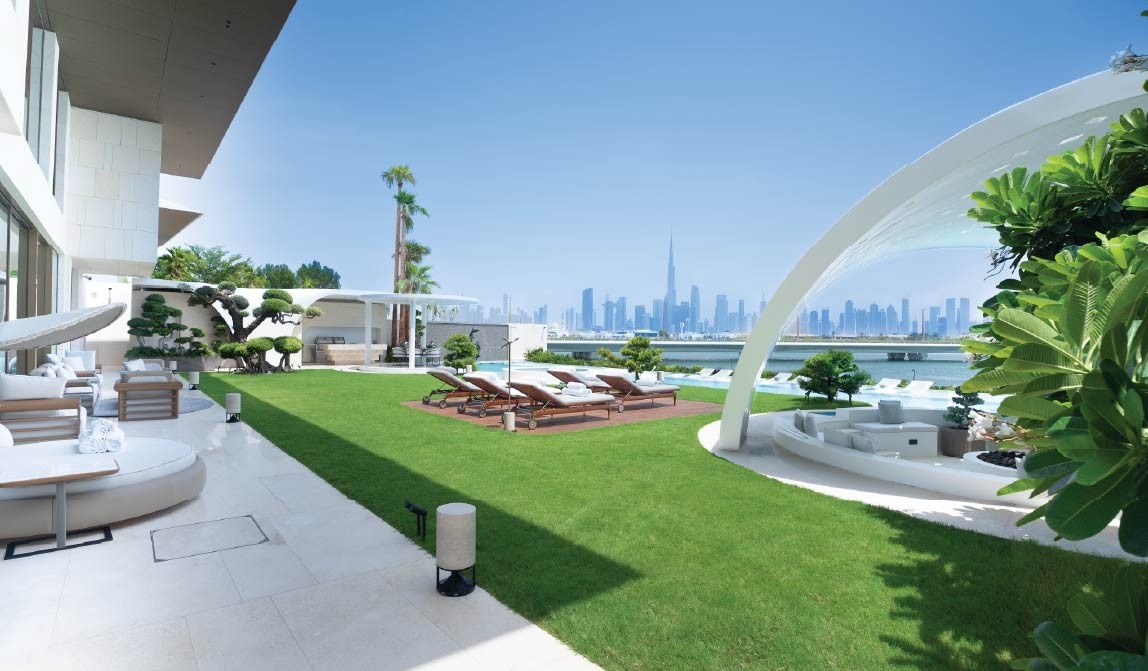 Garden and pool of the Bvlgari Mansion with the Downtown Dubai skyline across the water
